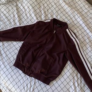 Maroon jacket with white strips on the sleeves
